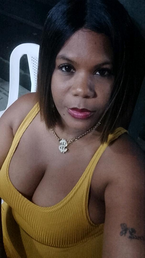 A woman in a yellow top looking into her front camera, ready to call strangers