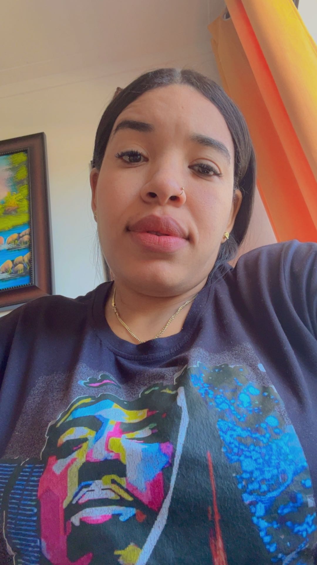 A woman in a printed T-shirt taking a selfie, a regular on TalkWithStrangerCam