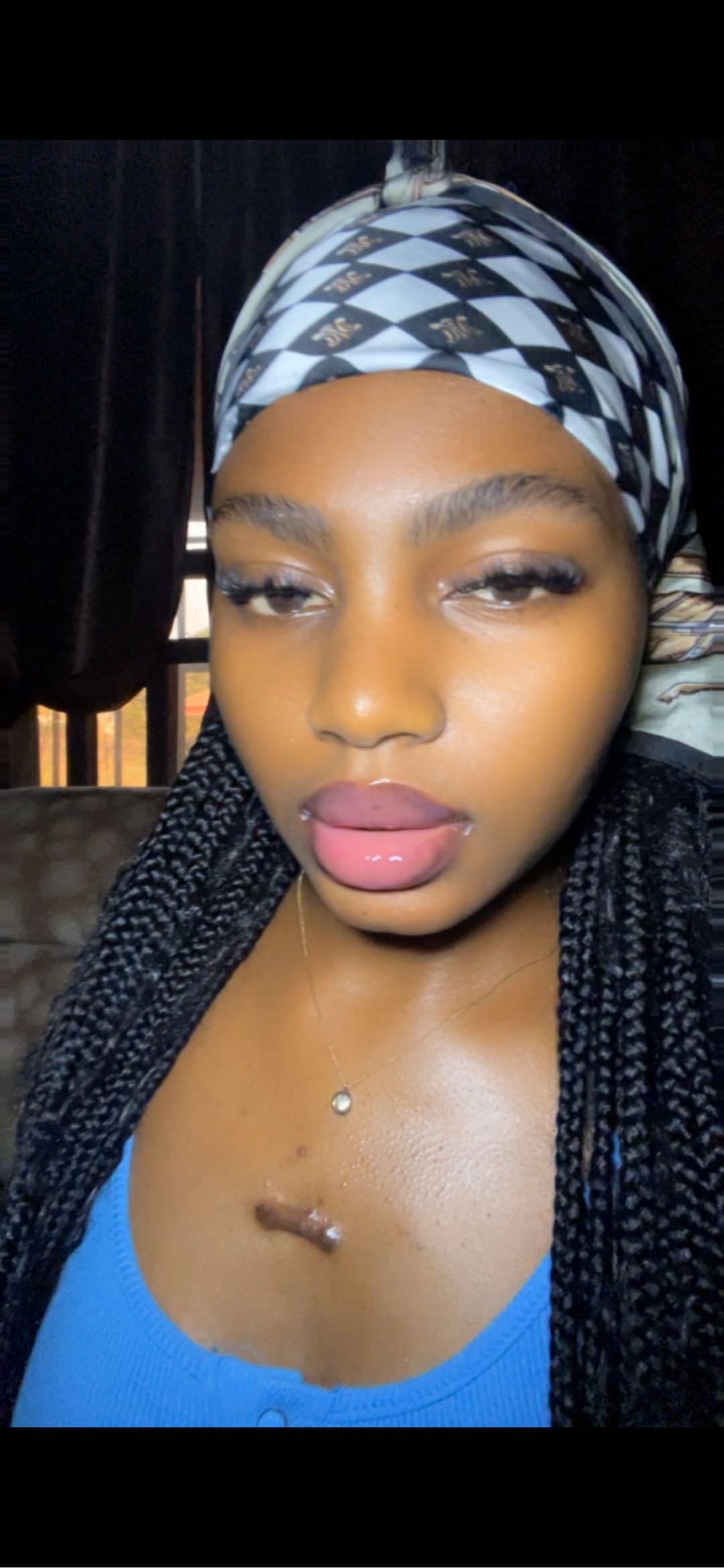 A woman in a headscarf looking into her phone camera