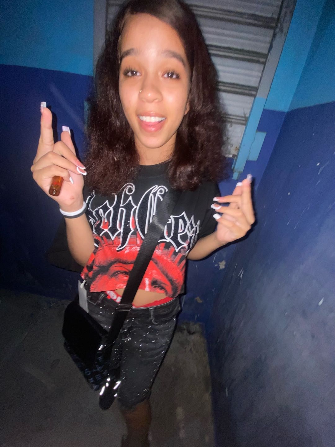 A young woman holding up two fingers with her phone camera, using the home screen app
