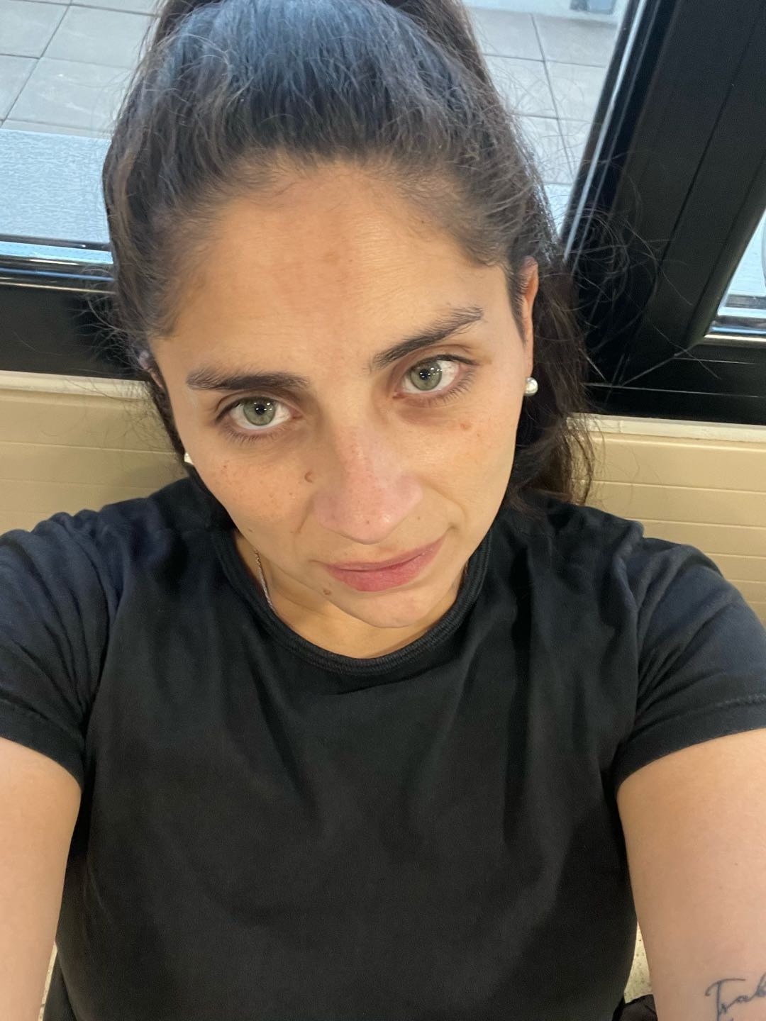 A woman with her hair tied back looking straight at the camera, first match on TalkWithStrangerCam