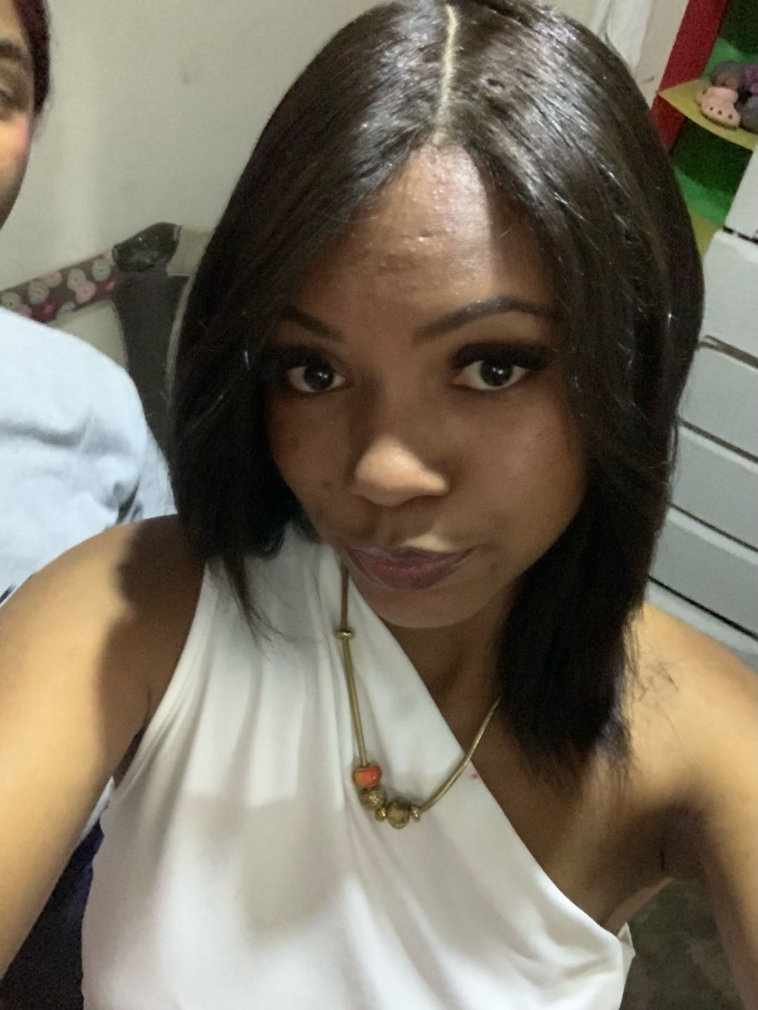 A woman in a white top taking a close selfie