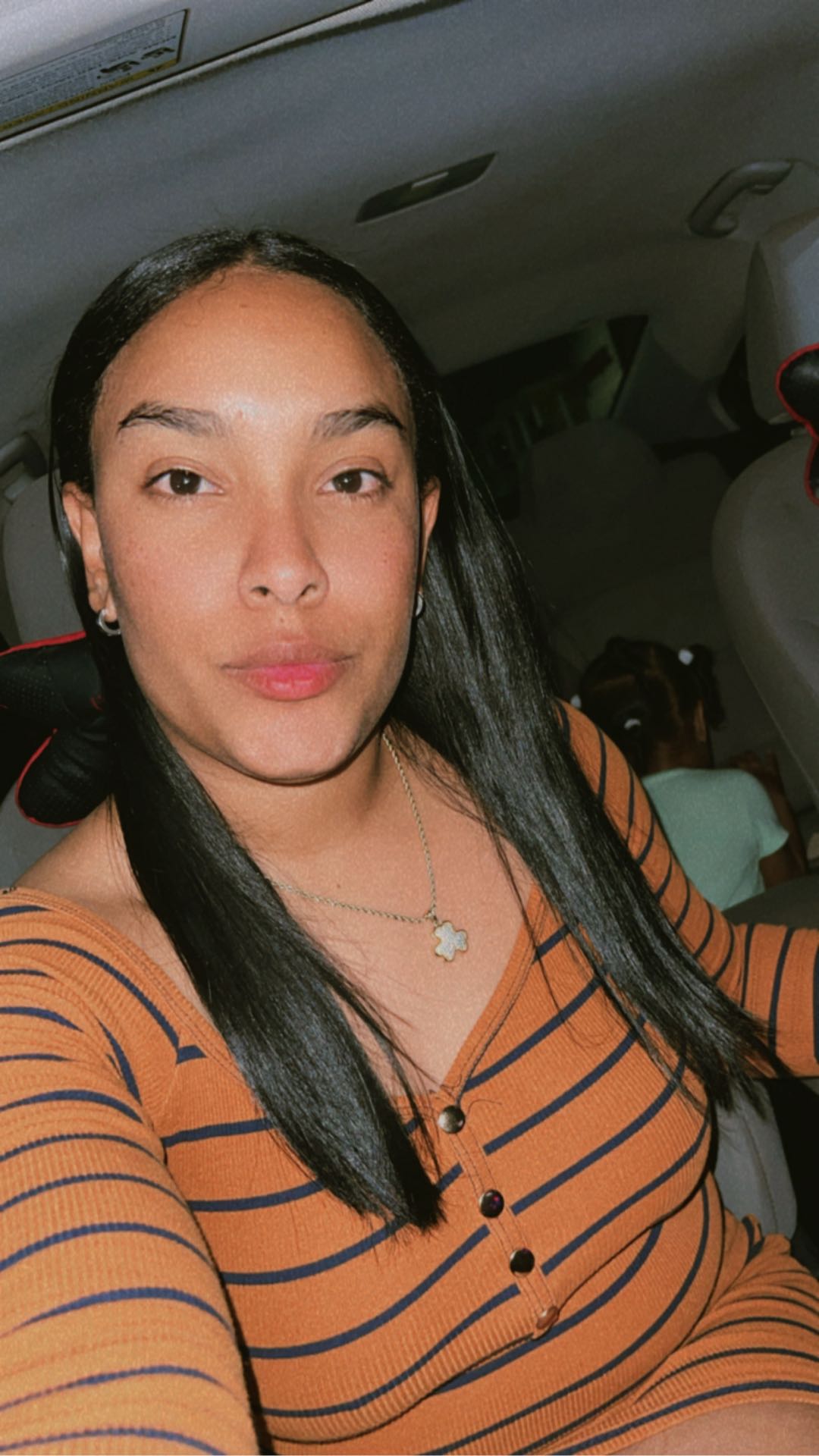 A woman in a striped top sitting in a car